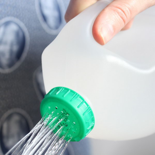 Make holes in the top of a used milk bottle for DIY watering can. 