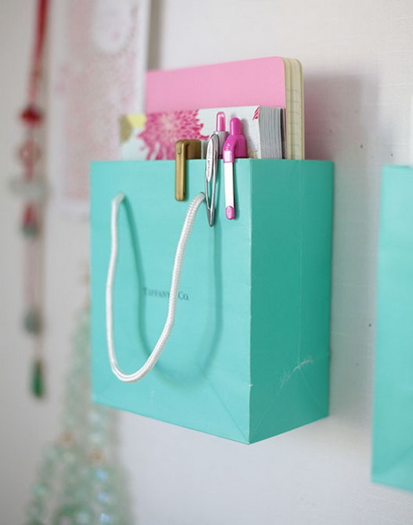 Shopping Bag Organization. Next time, don't throw away those really cute and really strong shopping bags.  You can actually repurpose them by mounting them on your wall and using them to store notebooks, magazines or other little office supplies. 