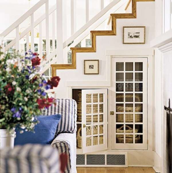 Mullioned glass pane doors add more elegance to this smart understair hideaway.  Baskets placed on the shelves are stylish storage  for your home. 