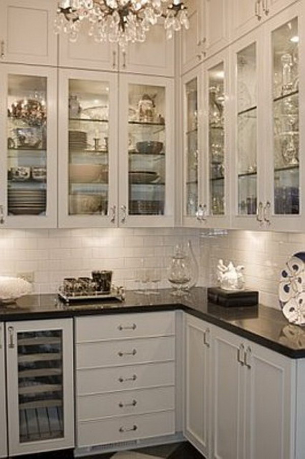 Black Countertops With Glass Cabinet Doors, Glass Shelves And Lighting. 