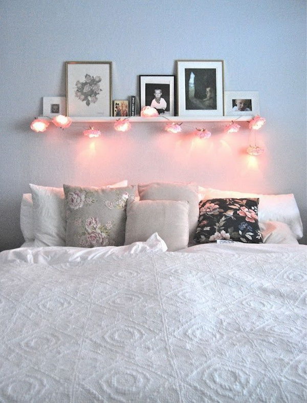 Shelf with Leaning Framed Photos and String Lights. 