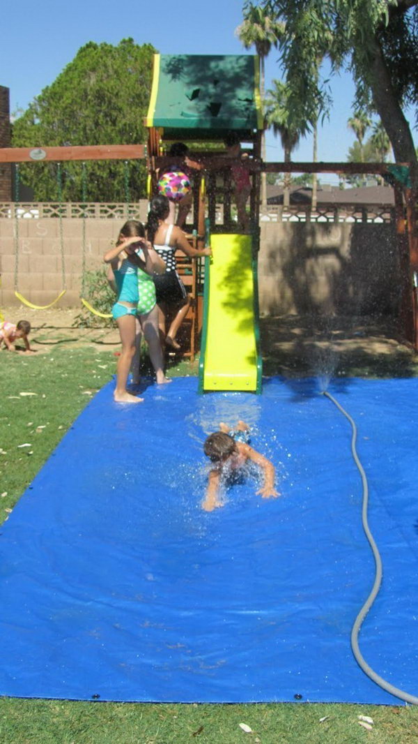 Use a tarp and sprinkler to create a fun splash pad for a slide 