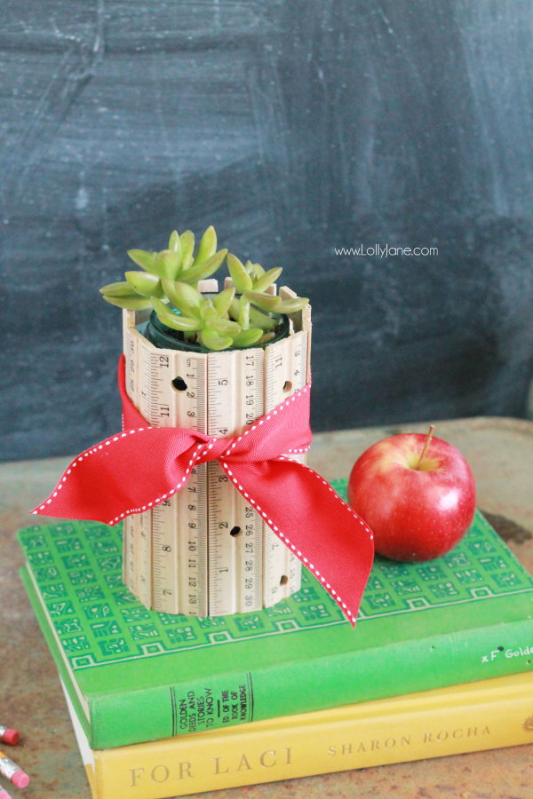 DIY Ruler Vase. Arrange the rulers with the same length in the shape of a vase, then tie with a red ribbon. It makes a perfect table centerpiece for your dinning room. See the detailes directions 