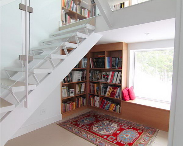 Create the open bookshelves under the stairs together with a reading nook besides the windows. 