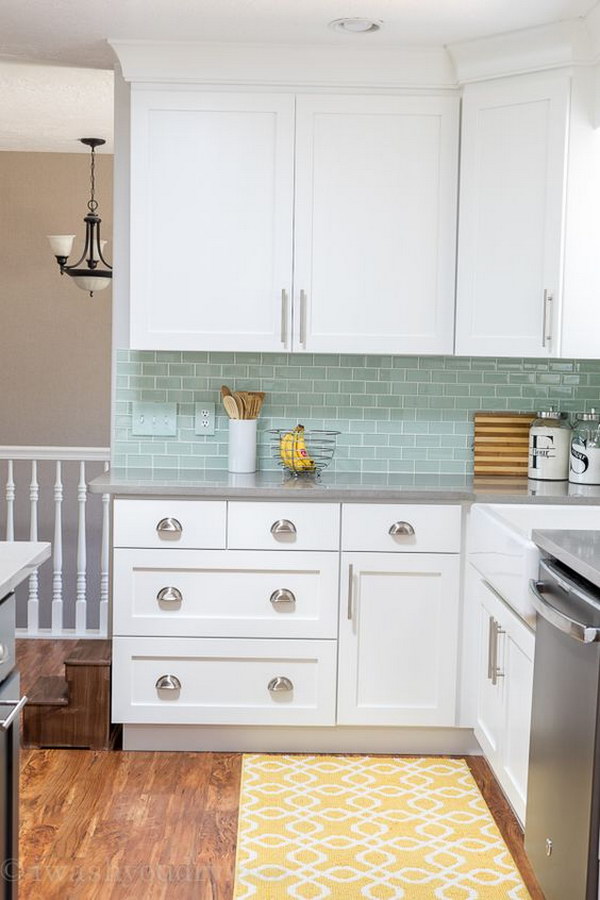 White Cabinets and Quartz Countertops That Look Like Concrete With Mint Backsplash Tiles. 