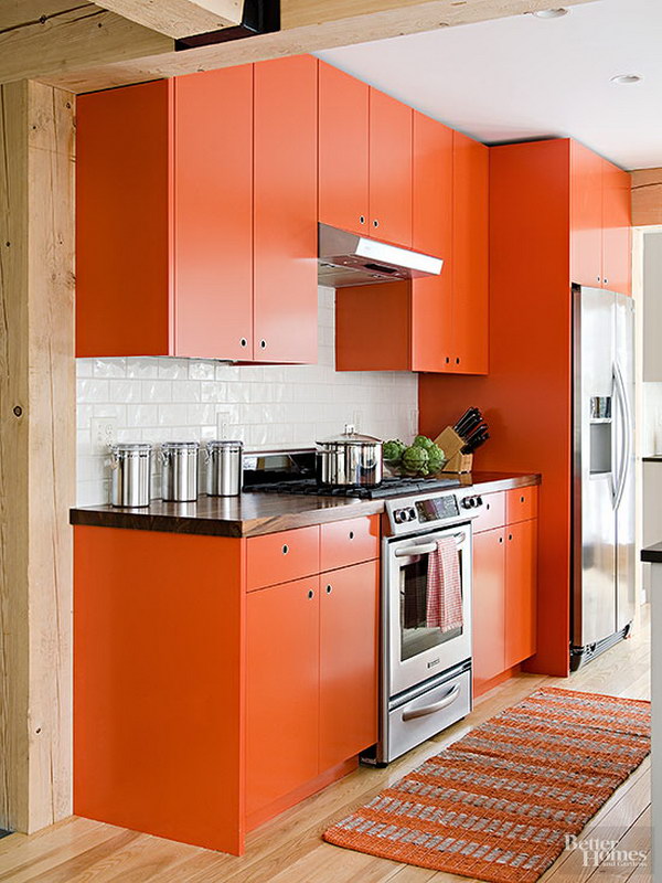 Orange Kitchen Cabinets with Crisp Black Countertops and Shiny White Backsplash. 