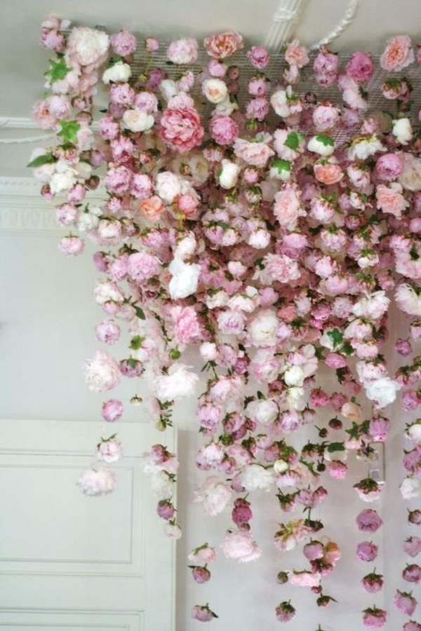 Photo Booth Backdrop With Fake Flowers Hanging From The Ceiling 